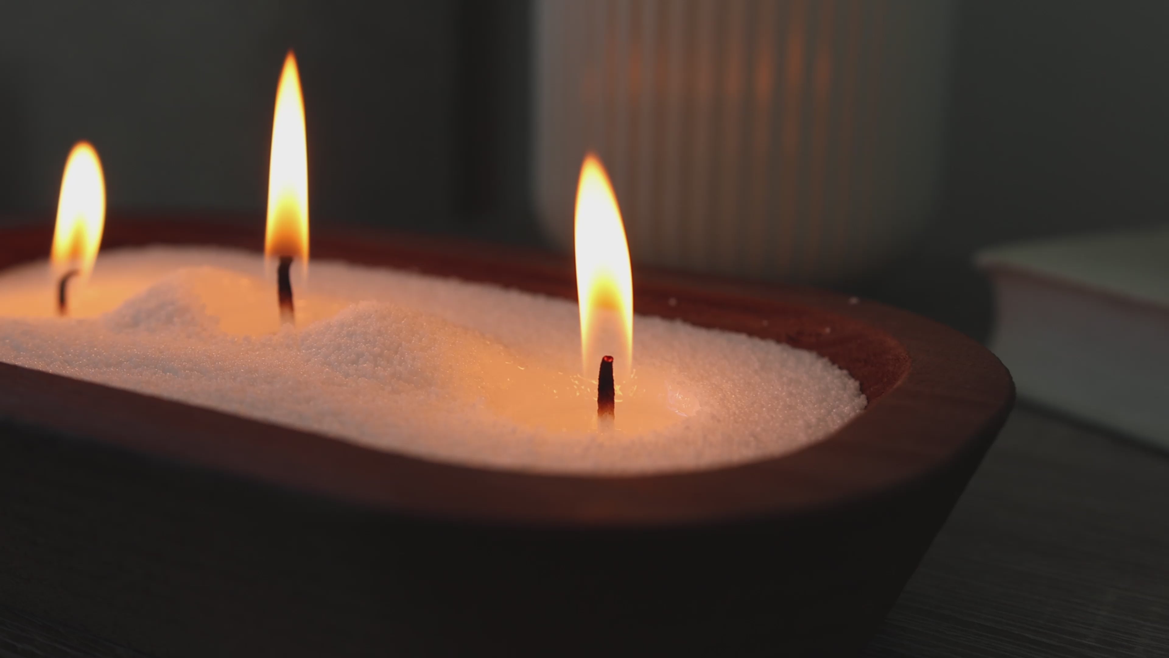 Refillable white pearled candle sand burning in a wooden bowl with cotton wicks. Clean, unscented candlelight for home decor, weddings, and events.
